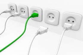 White multiple sockets in line with plugs and green plug for leadership stock photo