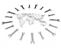 White world map surrounded with multiple wrenches stock photo