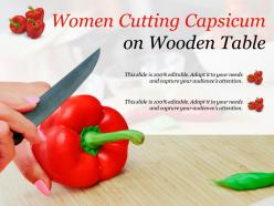 Women cutting capsicum on wooden table
