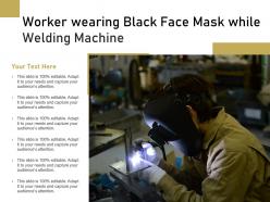 Worker wearing black face mask while welding machine