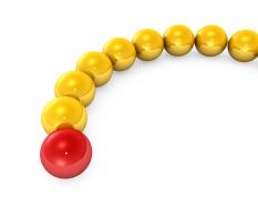 Yellow balls in line with red ball as leader stock photo