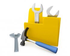 Yellow folder with two wrenches inside one hammer outside stock photo