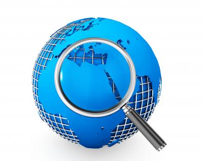 Blue globe with magnifying glass focusing on global issues stock photo