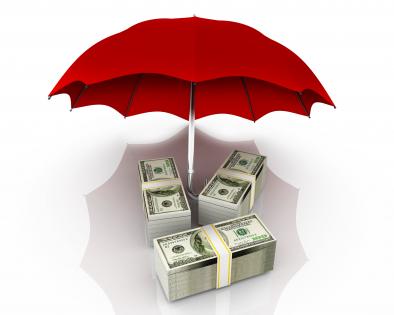 Bundles of dollars under red umbrella stock photo