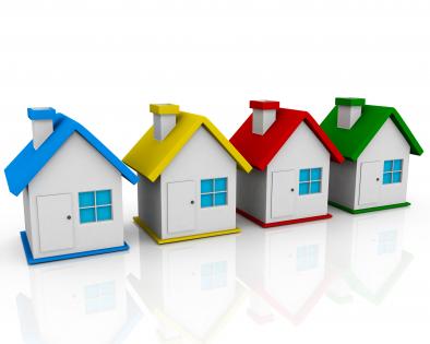 Four colored houses in queue shows real estate stock photo