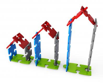 Huts of puzzle pieces represents concept of growth stock photo