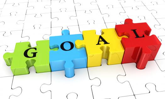 Multicolored puzzle with word goal on white puzzle base stock photo