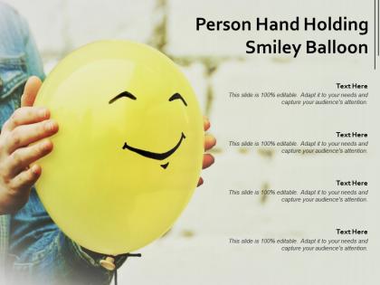 Person hand holding smiley balloon