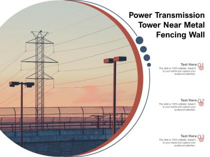 Power transmission tower near metal fencing wall