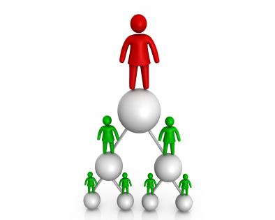 Red man standing on green pyramid made by balls stock photo