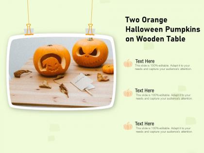 Two orange halloween pumpkins on wooden table