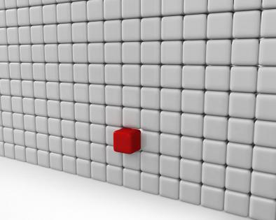 White cubes wall with one red block as leader stock photo